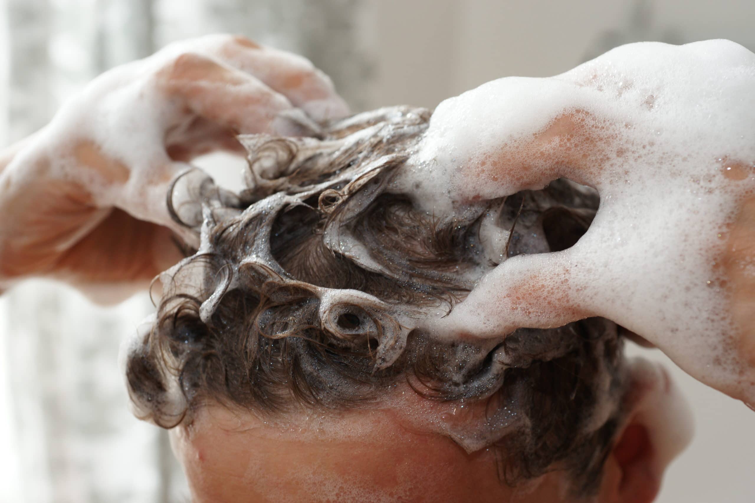 man washing his hair with shampoo