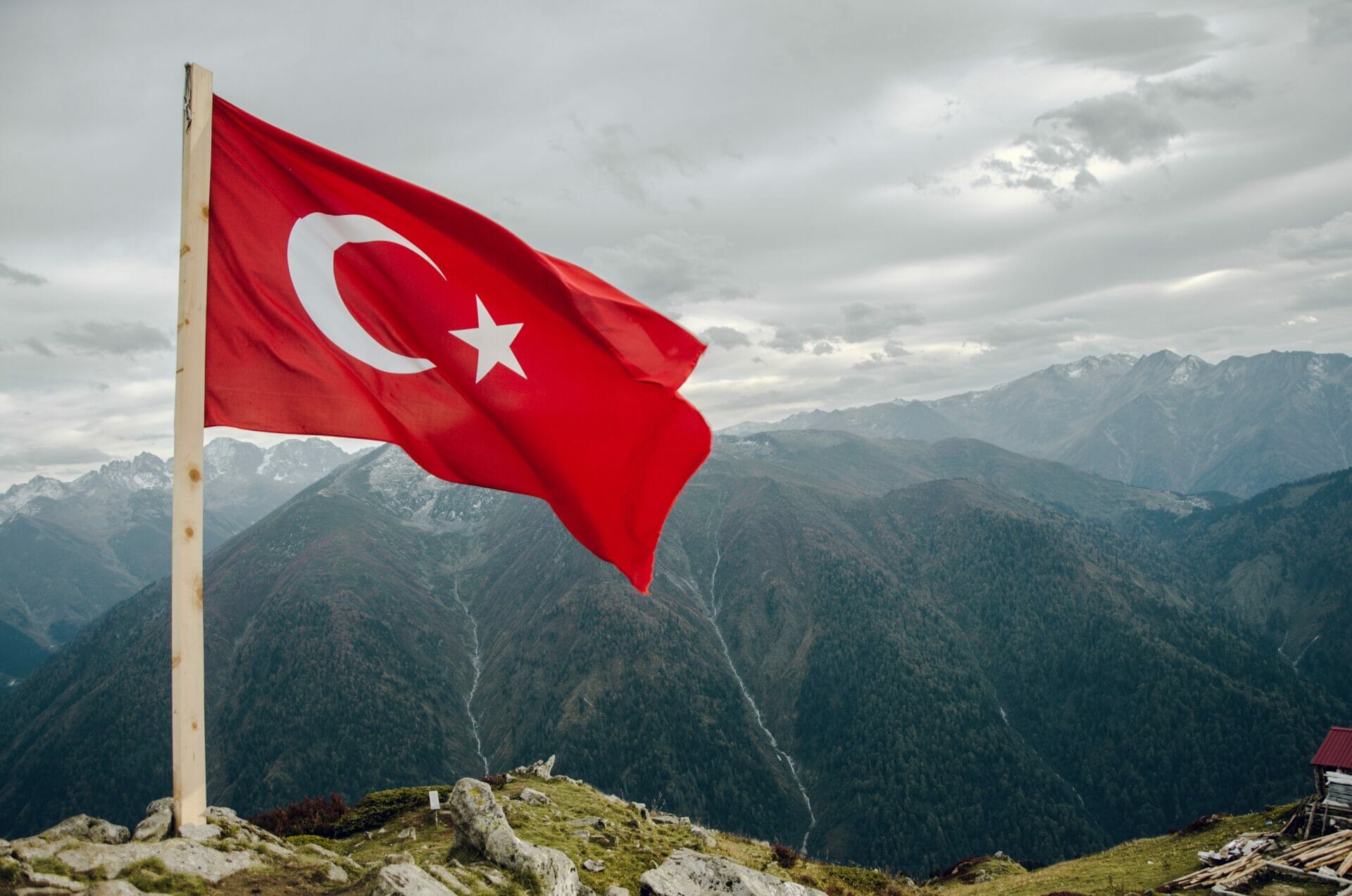 the flag of turkey over a mountain landscape